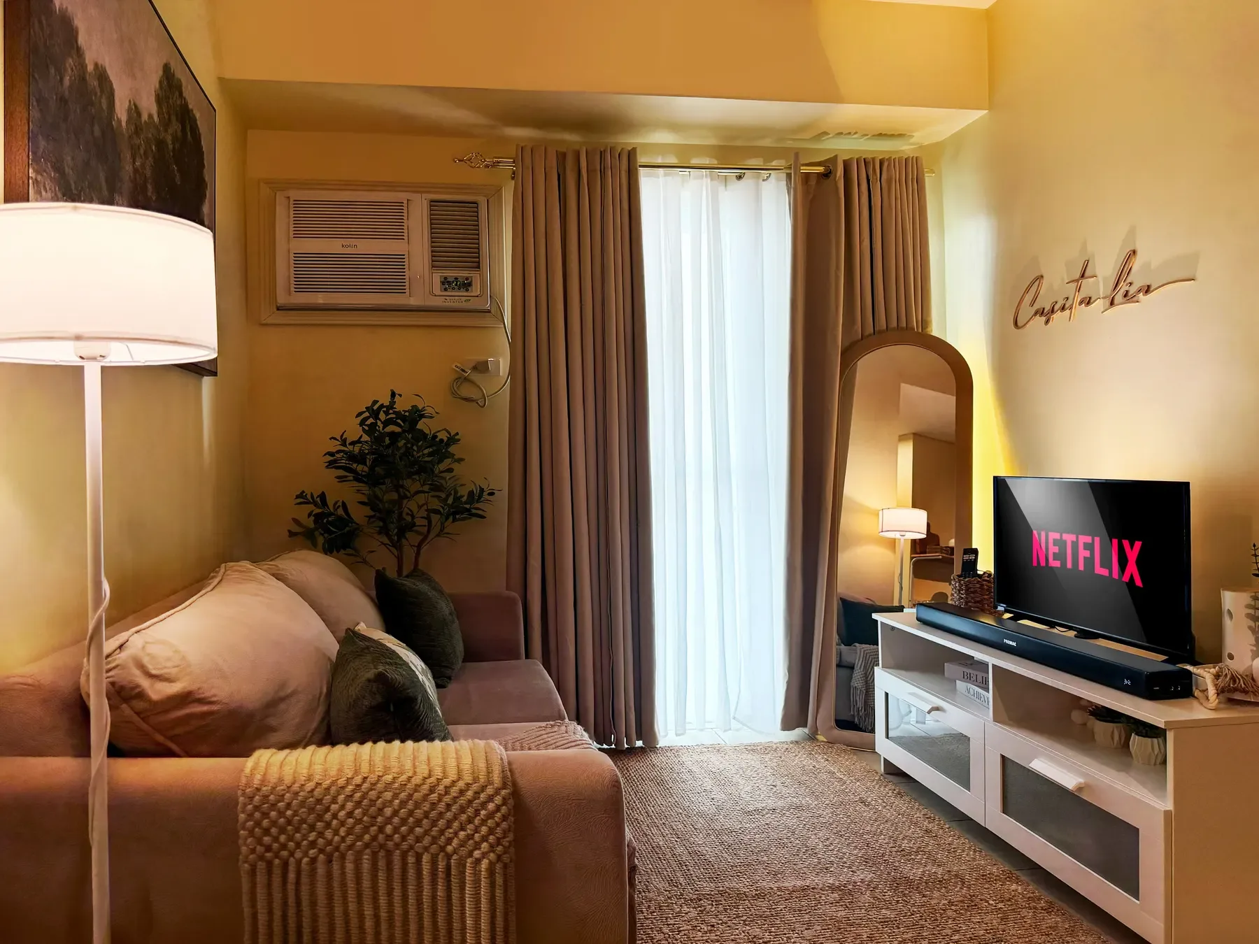 A warm living space with a spacious sofa and sunlit windows